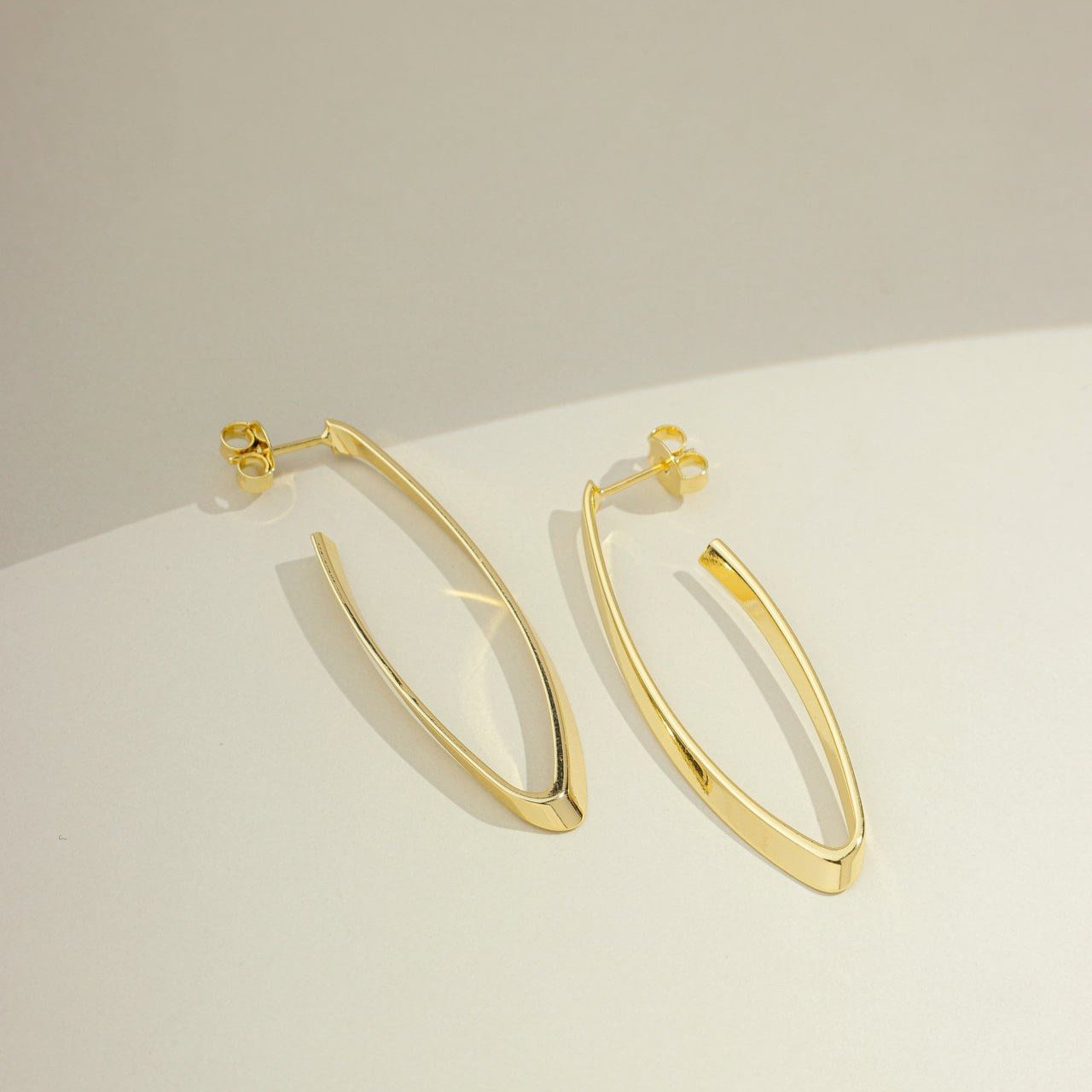 Brinco argola alongada oval grande lisa banhado a ouro 18k