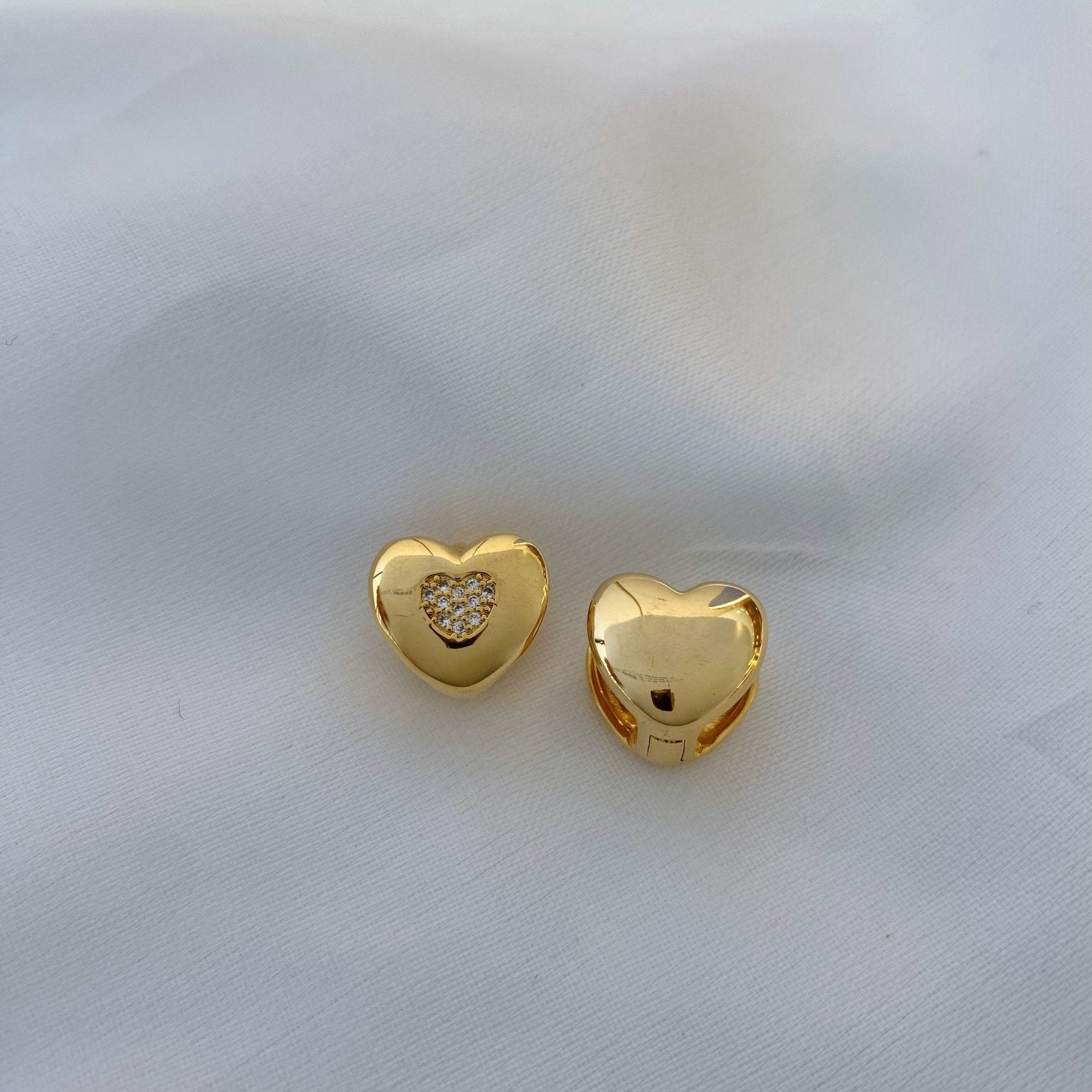 Brinco articulado em formato de coração liso com coração cravejado no meio banhado a ouro 18k