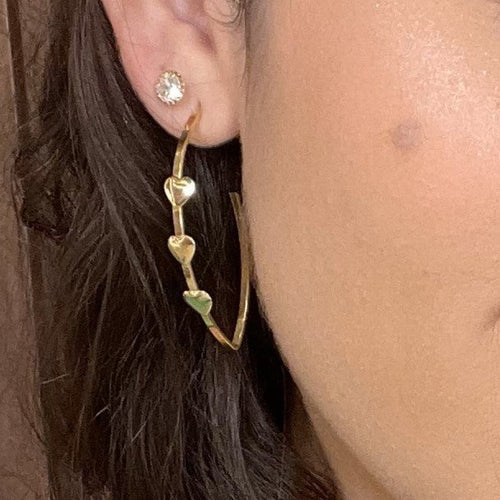 Brinco argola alongada com corações lisos banhado a ouro 18k